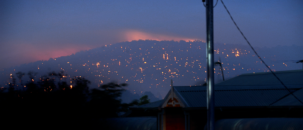 Photograph of a Perth hillside at night showing flames from fires