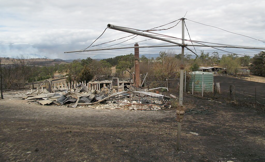 The ruined remains of a burnt-down house and hills hoist.