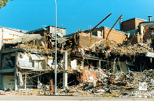 A photo the damaged Newcastle Workers Club. The building is essentially demolished, with parts of the building’s framework exposed and huge piles of rubble around it.