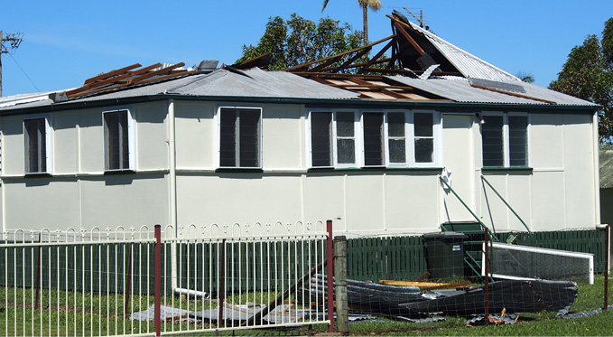 Image of a house with its roof partially torn away.