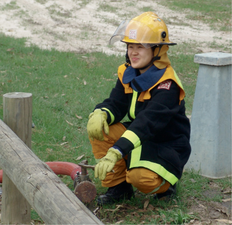 A young female firefighter operating a hydrant