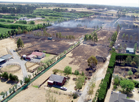 Aerial view of small rural blocks of land, some of which are blackened by a recent fire.
