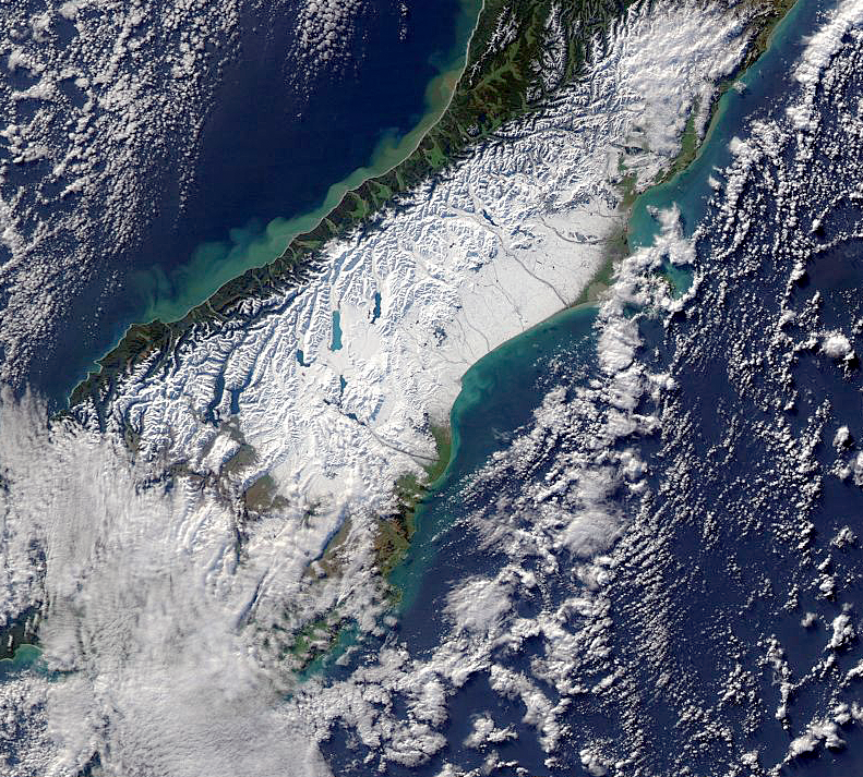 A satellite image of New Zealand's South Island showing that a significant proportion of the island is covered in snow.