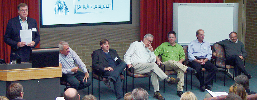 Peter Power, David Parsons, Professor Robert Kay, Nat Forbes, Professor Scot Phelps, Professor John Handmer, Dr John Bircham, seated in a row at the front of a lecture theatre.