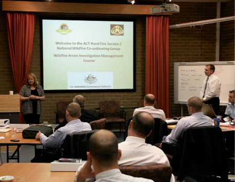 A presenter stands in front of many attendees undertaking the pilot course.