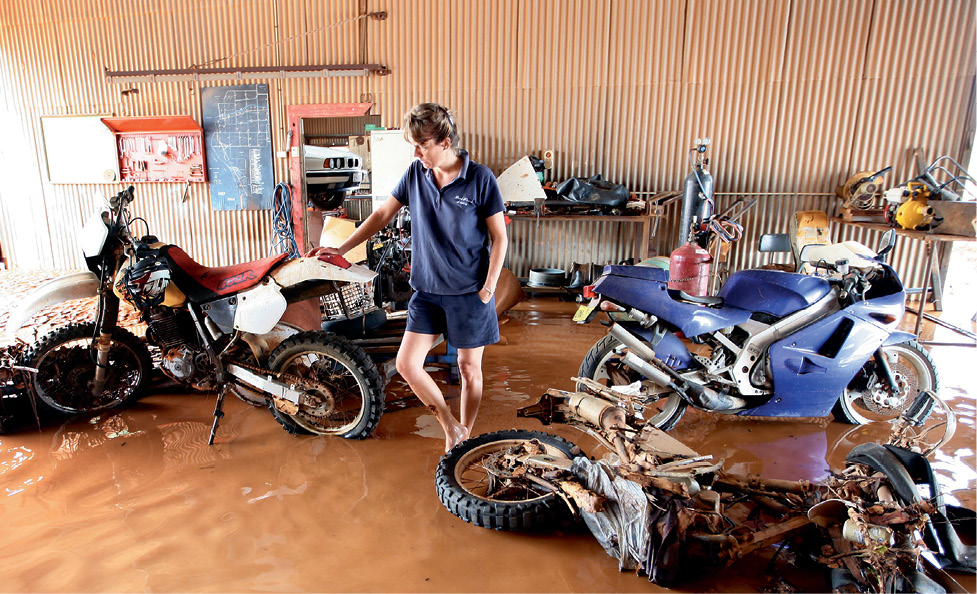 Photograph of Rebecca standing in her flooded garage.