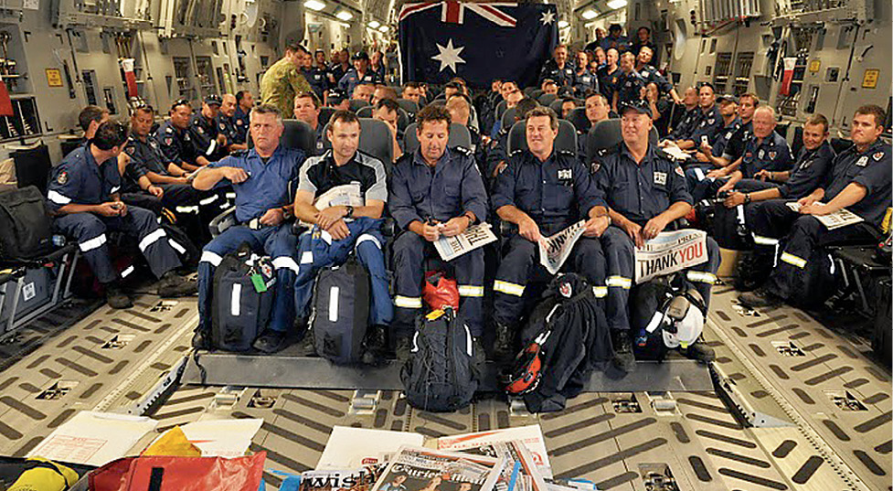 Photograph of the emergency team sitting in a cargo plane.