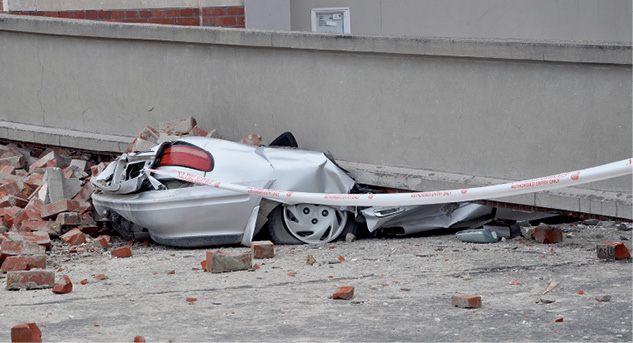 Photograph of a car smashed by a concrete beam.