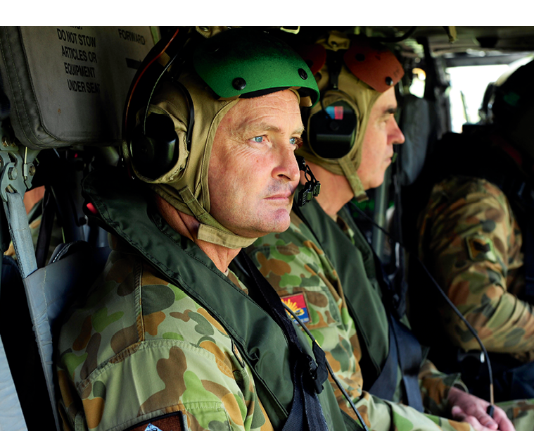 Photograph of army personnel sitting in a helicopter.