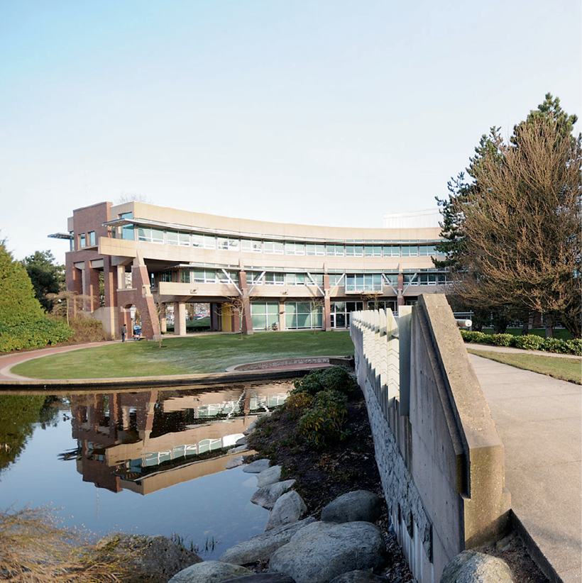 Photograph of the grounds around The Justice Institute of
British Columbia in Canada. There is a bridge and a pond in the foreground, with the building in the background.
