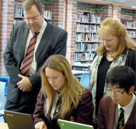 Photograph of the Hon Robert McClelland and Ms Raelene Thompson observing students using laptops in a library