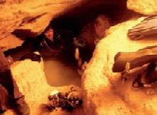 Photograph of team members and equipment inside the very close environment of the Tank Cave