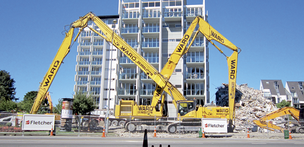 Photograph of an apartment building with heavy machinery in the foreground