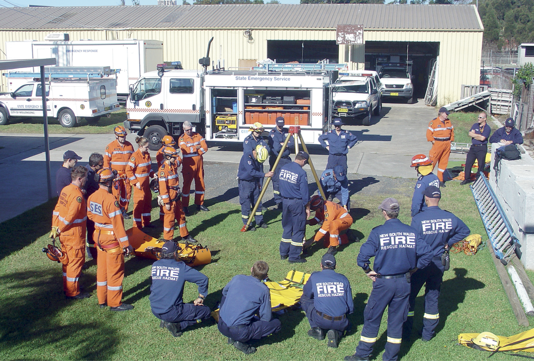 Photograph of emergency services staff in uniforms participating in an outdoor training exercise