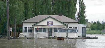 A cottage is surrounded by floodwaters.