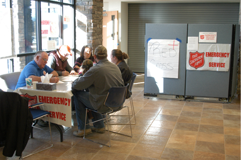 A photo of five Salvation Army volunteers having a discussion at a table.