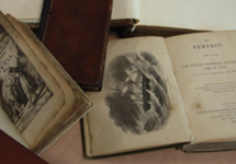 A photo of some old books. The pages are yellowed and the edges torn. They appear to be leather bound.