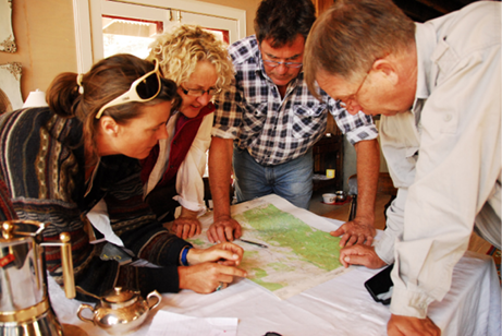 A photo of four people working at a table, looking at a map.