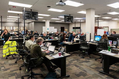 A photo of many people sitting in front of computers at the control centre.