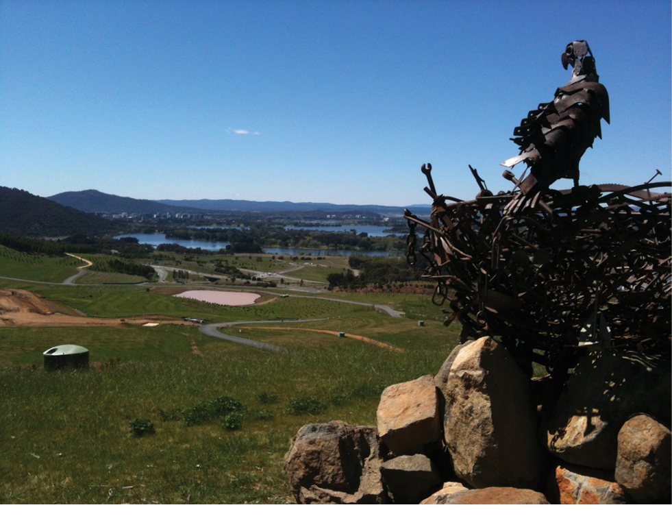 The eagle and nest sculpture in the foreground with the National Arboretum and the city of Canberra in the background