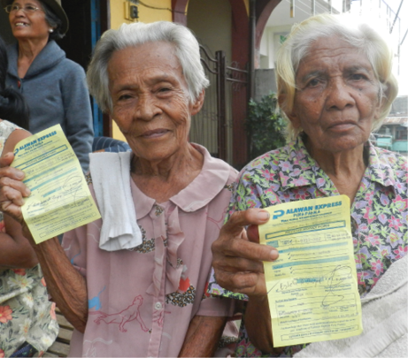Photo of two older people with their cash transfers.