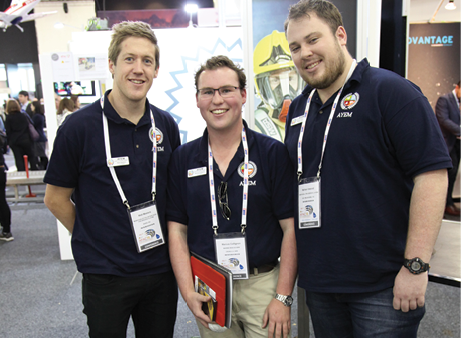 Three young men wearing polo shirts with the Australian Youth in Emergency Management logo and conference passes.