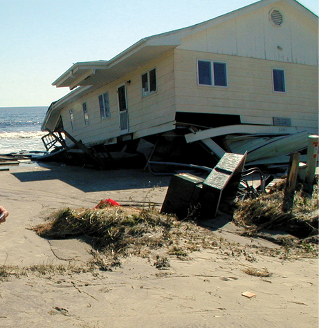 A timber bungalow right beside the ocean has collapsed onto the sand dunes.