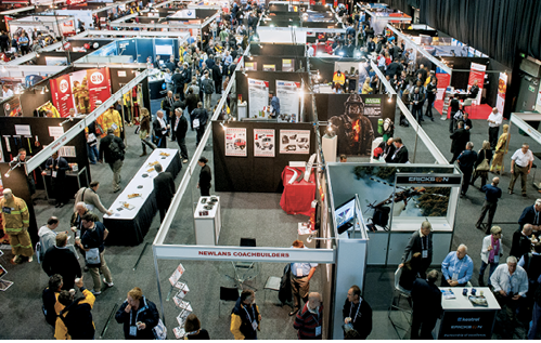 An overhead image of the trade show booths at the conference. There are people walking around looking at the displays.