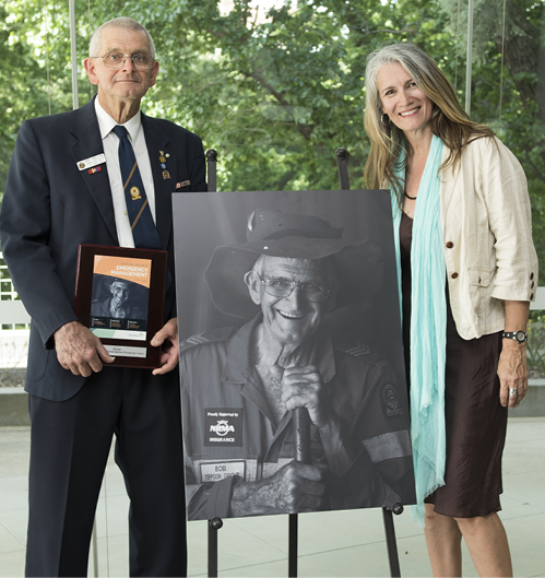 A photo of Bob Jeacocke and Karin Calvert with the 2016 Resilient Australia National Photography Award winning portrait. The portrait, taken by Karin, is of Bob, who has been an SES volunteer for over 42 years.