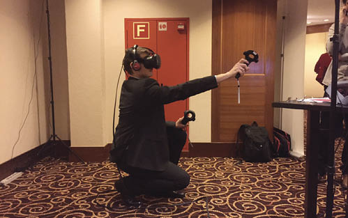 A photo of someone wearing goggles and using the virtual reality computer program. 