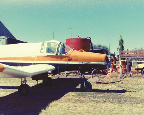 A photo of the firebase, which appears to be mostly grassland. The nose of the plane can be seen.