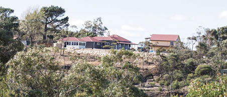 A photo of a home surrounded by bushland.