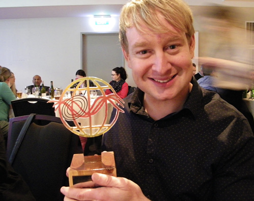 Image of Chris Lynch holding his award.